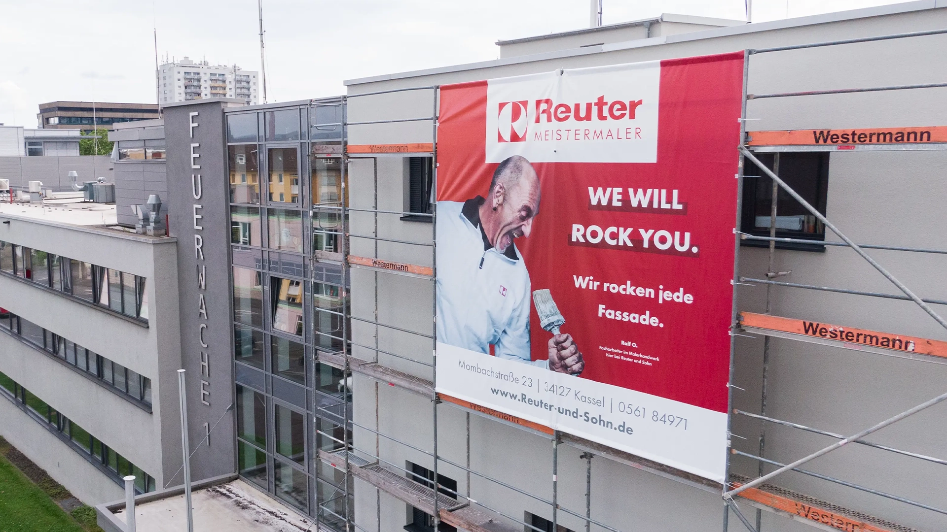 Reuter & Sohn - Scaffold Banner "We Will Rock You" on an Office Building